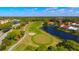 Scenic aerial shot of a golf course with a green, water hazards, and surrounding greenery at 9320 Clubside Cir # 2208, Sarasota, FL 34238
