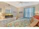 Comfortable bedroom features a ceiling fan, a flat screen TV, and floral bedding at 9320 Clubside Cir # 2208, Sarasota, FL 34238