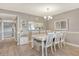 Dining room boasts a modern chandelier, white table and chairs, with wood look flooring at 9320 Clubside Cir # 2208, Sarasota, FL 34238
