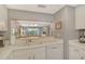 Kitchen view featuring white cabinetry and a pass-through to the living and dining areas at 9320 Clubside Cir # 2208, Sarasota, FL 34238