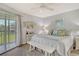 The primary bedroom features coastal decor, a ceiling fan, and a balcony at 9320 Clubside Cir # 2208, Sarasota, FL 34238