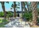 Outdoor patio area with table and chairs, surrounded by lush greenery at 9320 Clubside Cir # 2208, Sarasota, FL 34238