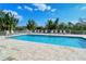 Inviting community pool with plenty of lounge chairs and lush tropical foliage at 9320 Clubside Cir # 2208, Sarasota, FL 34238