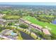 Community aerial view showcases golf course, swimming pools, tennis courts, and residential buildings at 9641 Castle Point Dr # 1215, Sarasota, FL 34238