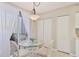 Bright breakfast nook with a glass table and white chairs by a window with sheer curtains at 9641 Castle Point Dr # 1215, Sarasota, FL 34238