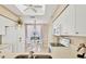 Sunlit kitchen with white cabinets, stainless appliances and view of the breakfast nook with sliding glass doors at 9641 Castle Point Dr # 1215, Sarasota, FL 34238