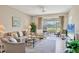 Inviting living room with neutral tones, comfortable seating, and a view of the green landscape at 9641 Castle Point Dr # 1215, Sarasota, FL 34238