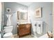 Bathroom with wood vanity, framed mirror, decorative lighting, and neutral walls at 1108 65Th W Ave, Bradenton, FL 34207