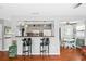 Kitchen with a breakfast bar, dark countertops, tile floors, and view into dining area at 1108 65Th W Ave, Bradenton, FL 34207