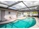 Screened-in pool with tiled deck and views to backyard and patio at 1108 65Th W Ave, Bradenton, FL 34207