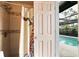 Bathroom with a tile shower next to an open door to a refreshing, private pool at 1108 65Th W Ave, Bradenton, FL 34207