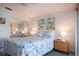 Cozy bedroom with blue and white bedding, beach-themed artwork, and a mirrored closet at 1255 E Peppertree Dr # 506, Sarasota, FL 34242