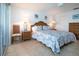 Comfortable bedroom with wicker furniture, beach-themed artwork, and tiled flooring at 1255 E Peppertree Dr # 506, Sarasota, FL 34242