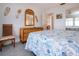 Bright bedroom featuring coastal decor, chair, and a glimpse into the ensuite bathroom at 1255 E Peppertree Dr # 506, Sarasota, FL 34242