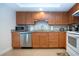 Well-equipped kitchen with stainless steel appliances, wood cabinets, and light granite countertops at 1255 E Peppertree Dr # 506, Sarasota, FL 34242