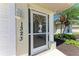 Close-up of the decorative storm door featuring a palm tree design with fresh landscaping at 1323 Arredondo St, North Port, FL 34286