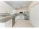 Modern kitchen featuring white cabinets, granite countertops, stainless steel appliances, and tile flooring at 1323 Arredondo St, North Port, FL 34286