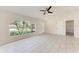 Bright living room boasts tile flooring, ceiling fan, and large window, creating an inviting space at 1323 Arredondo St, North Port, FL 34286