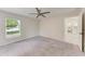 Spacious main bedroom featuring a ceiling fan, carpet flooring, and an en-suite bathroom at 1323 Arredondo St, North Port, FL 34286