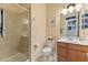 Bathroom featuring a shower with glass door, toilet, and vanity with mirror and lighting at 13409 Ramblewood Trl, Bradenton, FL 34211
