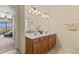 Bright bathroom featuring double sinks, vanity with wood cabinets, and a view into the bedroom at 13409 Ramblewood Trl, Bradenton, FL 34211