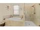 Bathroom features a bathtub with custom tile and a separate glass door shower at 13409 Ramblewood Trl, Bradenton, FL 34211