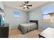 Bedroom featuring neutral carpet, blue walls, ceiling fan, and two windows at 13409 Ramblewood Trl, Bradenton, FL 34211