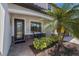 Inviting home entrance features a stylish front door, a cozy seating area, and lush tropical landscaping at 13409 Ramblewood Trl, Bradenton, FL 34211