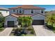 Charming home with a red tile roof, lush landscaping, and a paver driveway leading to a spacious two-car garage at 13409 Ramblewood Trl, Bradenton, FL 34211