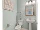 Stylish half bathroom with modern fixtures, decorative mirror, and marine themed decor at 13409 Ramblewood Trl, Bradenton, FL 34211