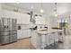 Bright kitchen with white cabinets, granite countertops, stainless steel appliances and an island with bar seating at 13409 Ramblewood Trl, Bradenton, FL 34211