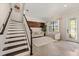 Bright living room with a staircase, stylish rug, comfortable seating, and plenty of natural light for a welcoming ambiance at 13409 Ramblewood Trl, Bradenton, FL 34211