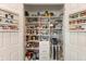 Walk-in pantry with shelving, drawers, and spice racks for organized storage of food items at 13409 Ramblewood Trl, Bradenton, FL 34211