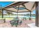 Community picnic area with tables, stone pillars, and a view of the lake and nearby homes at 13409 Ramblewood Trl, Bradenton, FL 34211