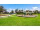 Community playground with green equipment on a sunny day near the lake at 13409 Ramblewood Trl, Bradenton, FL 34211