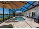 Screened in pool with a spa, outdoor kitchen and dining area with a view of the canal at 13409 Ramblewood Trl, Bradenton, FL 34211