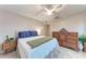 A cozy bedroom features blue pillows, a green blanket, and classic wooden furniture at 1520 Lakeside Way # 147, Sarasota, FL 34232