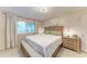 Serene bedroom with a queen-size bed, bench, neutral tones, and natural light at 1520 Lakeside Way # 147, Sarasota, FL 34232