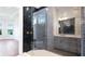 Modern bathroom featuring a glass enclosed shower with dark tiled walls and a view into the bedroom at 15722 San Lazzaro Ave, Lakewood Ranch, FL 34211
