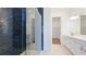 Modern bathroom featuring a glass enclosed shower, double vanity sinks, and stylish gold accents at 15722 San Lazzaro Ave, Lakewood Ranch, FL 34211