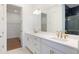 Bright bathroom featuring a double sink vanity, sleek white cabinets, gold hardware, and a glass shower at 15722 San Lazzaro Ave, Lakewood Ranch, FL 34211