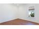 Bright bedroom with hardwood floors and a window providing natural light and views of the neighborhood at 15722 San Lazzaro Ave, Lakewood Ranch, FL 34211