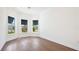 Bright bedroom showcasing hardwood floors, crown molding, and large windows offering neighborhood views at 15722 San Lazzaro Ave, Lakewood Ranch, FL 34211