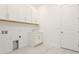 Clean laundry room with white cabinets, sink, and tile floor at 15722 San Lazzaro Ave, Lakewood Ranch, FL 34211