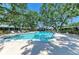 Inviting community pool area with lounge chairs and mature shade trees at 1622 Stafford Ln # 1205, Sarasota, FL 34232
