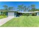 Charming single-story home with a well-maintained lawn, attached garage, and colorful green siding at 1622 Stafford Ln # 1205, Sarasota, FL 34232