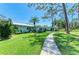 Beautiful home featuring a lush green lawn and sidewalk leading to the front door, with palm tree and mature landscaping at 1622 Stafford Ln # 1205, Sarasota, FL 34232