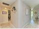 Well-lit hallway features decorative wall art and neutral color palette at 1622 Stafford Ln # 1205, Sarasota, FL 34232