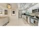 Bright kitchen featuring stainless steel appliances, white cabinets, and modern lighting at 1622 Stafford Ln # 1205, Sarasota, FL 34232
