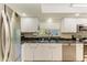 Well-lit kitchen features white cabinets, stainless steel appliances, and a granite countertop at 1622 Stafford Ln # 1205, Sarasota, FL 34232